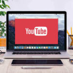 Trump’s H-1B Plan Comes With a $100K SHOCK YouTube logo on a laptop screen on desk.