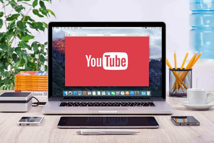 293731811-3 YouTube logo on a laptop screen on desk.