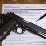 Handgun on a firearms transaction form with a pen