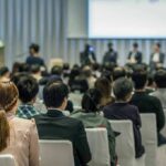 Audience listening to a panel discussion in a conference hall