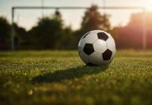 Soccer ball on grass field near goal