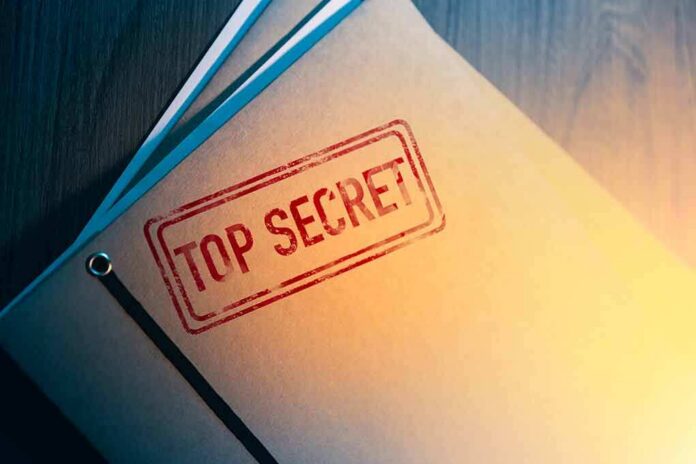 shutterstock_1189065697 Manila folder stamped top secret on a desk