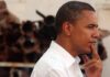 Barack Obama in profile, touching his chin thoughtfully