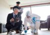 Forensic investigator collects evidence as police and detective observe