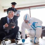 Forensic investigator collects evidence as police and detective observe