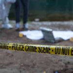 Police crime scene with yellow tape and forensic team