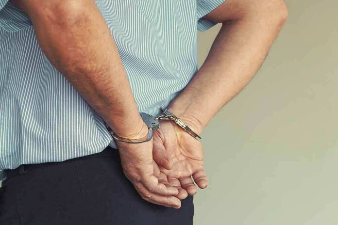 shutterstock_1616413276 person in handcuffs with hands behind back