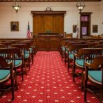 Heir Dismembers Neighbor—Walks Free Courtroom with wooden benches facing the judge's bench