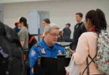 Bill Bergey, a TSA officer, checks a traveler's documents at an airport security checkpoint