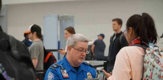 Bill Bergey, a TSA officer, checks a traveler's documents at an airport security checkpoint