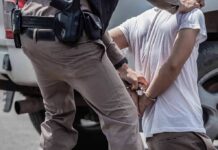 Bodycam Footage Debunks Claims Made by Illegal Shot by ICE Officer police officer handcuffing a person beside a vehicle