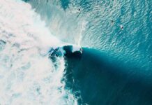 California City Declares Emergency After Taking a Beating Surfer riding a large turquoise wave from above