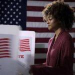 This Victory Could Change The Democratic Party Voter at a polling booth with an American flag backdrop