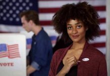 Voter showing an I Voted sticker at a polling place