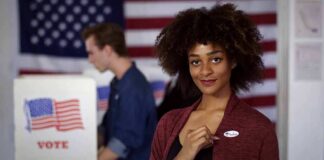 Voter showing an I Voted sticker at a polling place