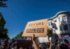 protesters holding signs at a street demonstration