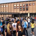 Students gathered outside a school building entrance
