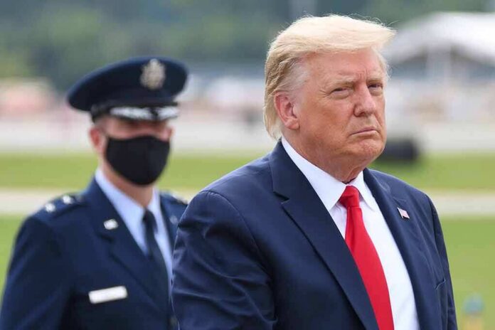 Donald Trump walking outdoors with an officer behind him; Chuck Howley not visible