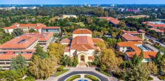 Aerial view of a campus building with red-tile roofs and a round fountain plaza