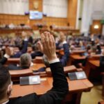 France Slams Door On Teen Screens Legislators raise hands during a vote in a large chamber