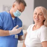 Smiling woman receiving a vaccination from a healthcare worker
