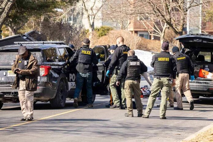 shutterstock_2126536382-1 Police and sheriff officers gather around vehicles on a suburban street