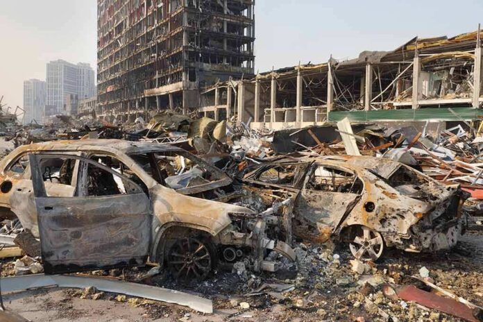 Burned cars amid rubble in a destroyed urban area