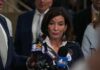 Woman speaking to reporters at a press scrum