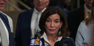 Woman speaking to reporters at a press scrum