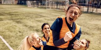 Women's soccer teammates celebrate lifting a player