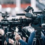 Double-Amputee Vet SHREDS Sailors Complaining About Food Broadcast cameras on tripods at a press event