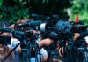 14 Charged in Penn State Cocaine Ring Tied to Frat Rituals TV news cameras crowding together at an outdoor event