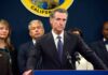 Man in suit at podium with microphones during press conference