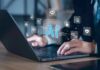 Hands typing on laptop with AI and tech icons overlay