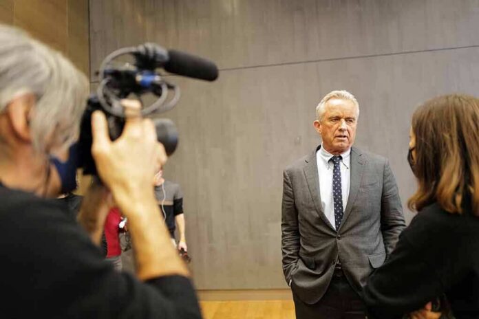 Robert F. Kennedy Jr. speaks with a reporter while being filmed indoors