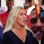 Blonde woman speaking to media at an outdoor event
