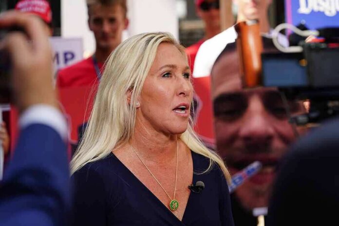 Blonde woman speaking to media at an outdoor event