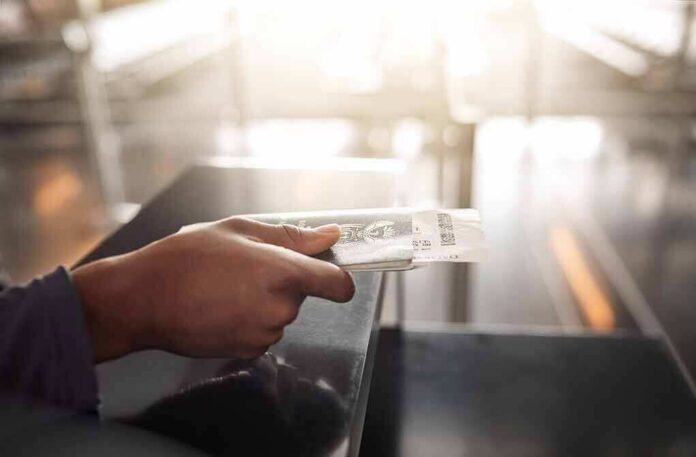 Hand holding a passport and boarding pass at an airport counter