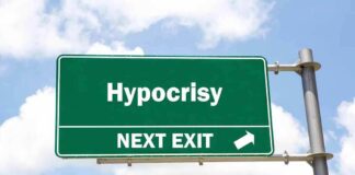 Green highway sign reading hypocrisy next exit