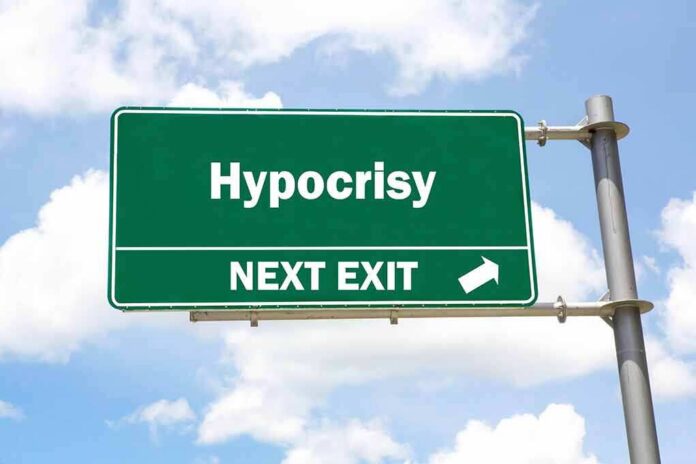 Green highway sign reading hypocrisy next exit