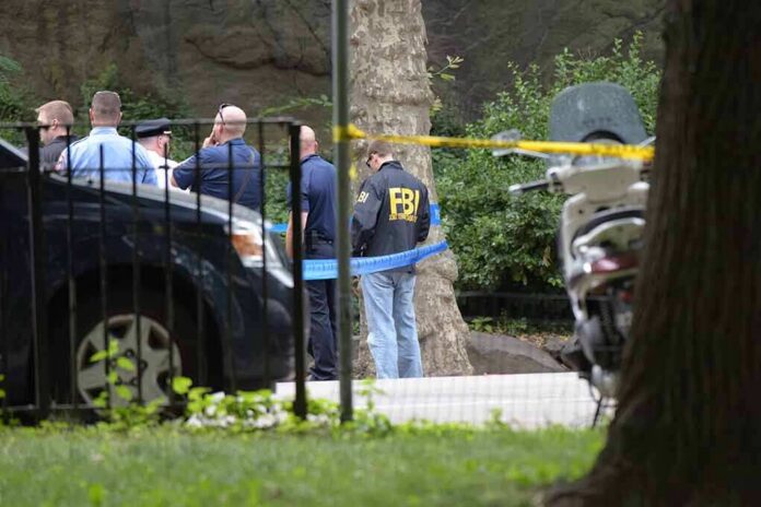 shutterstock_451587268 law enforcement officers gather at taped-off outdoor scene