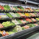 Grocery store produce aisle with stacked fresh vegetables