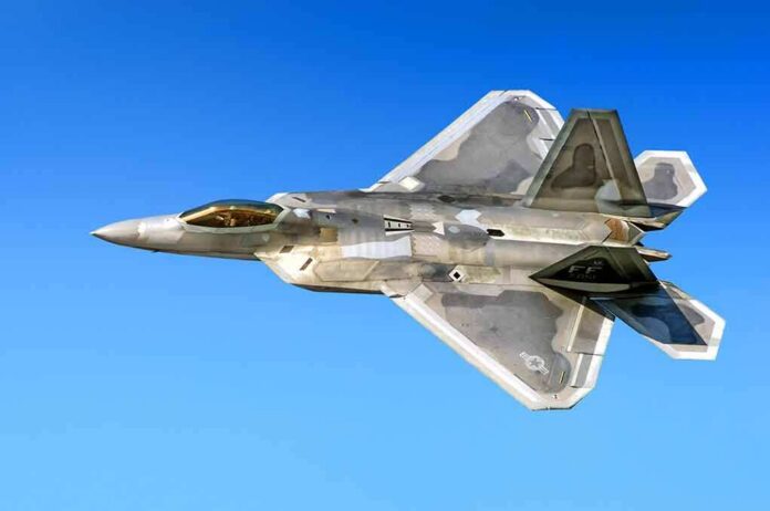 Stealth fighter jet in flight against a clear blue sky