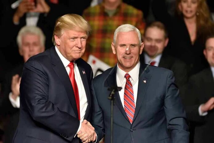 Donald Trump and Mike Pence shake hands on stage; Jeff Lord is in the background