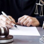 Attorney General Indicted—16 Felonies Stuns State Judge writing at desk with gavel and Lady Justice statue