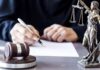 Court Bombshell: AI Porn Loophole Exposed Judge writing at desk with gavel and Lady Justice statue