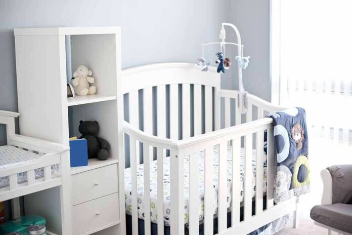 shutterstock_753586648 White baby crib with mobile in a bright nursery