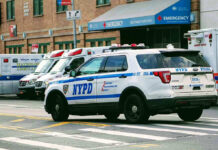 Police car and ambulances outside emergency room entrance.