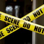 Yellow crime scene tape crossing a doorway
