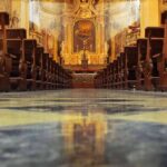 Livestream Catches Priest’s FINAL Moments at Mass Church interior with wooden pews facing ornate altar